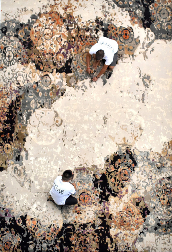 abstract area rug with a modern distressed pattern in cream, rust, orange, plum, and charcoal gray