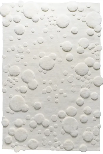 custom handmade ivory rug with sculpted circular texture and raised dimensional detailing on a soft neutral background
