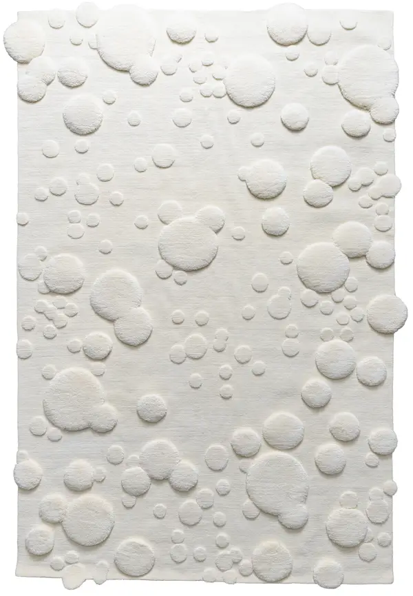 custom handmade ivory rug with sculpted circular texture and raised dimensional detailing on a soft neutral background